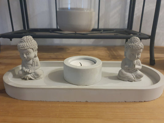 Modernes Deko-Set mit zwei Buddha-Figuren, Teelichthalter und ovalem Tablett aus hellgrauem Feinbeton – stilvolle Meditationsdeko für Wohnzimmer oder Yogaecke.