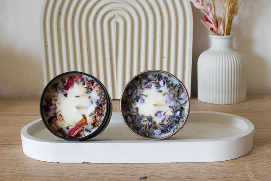 Sojawachskerzen in edlen Dosen, arrangiert auf einem Beton-Tablett im modernen Wohnstil