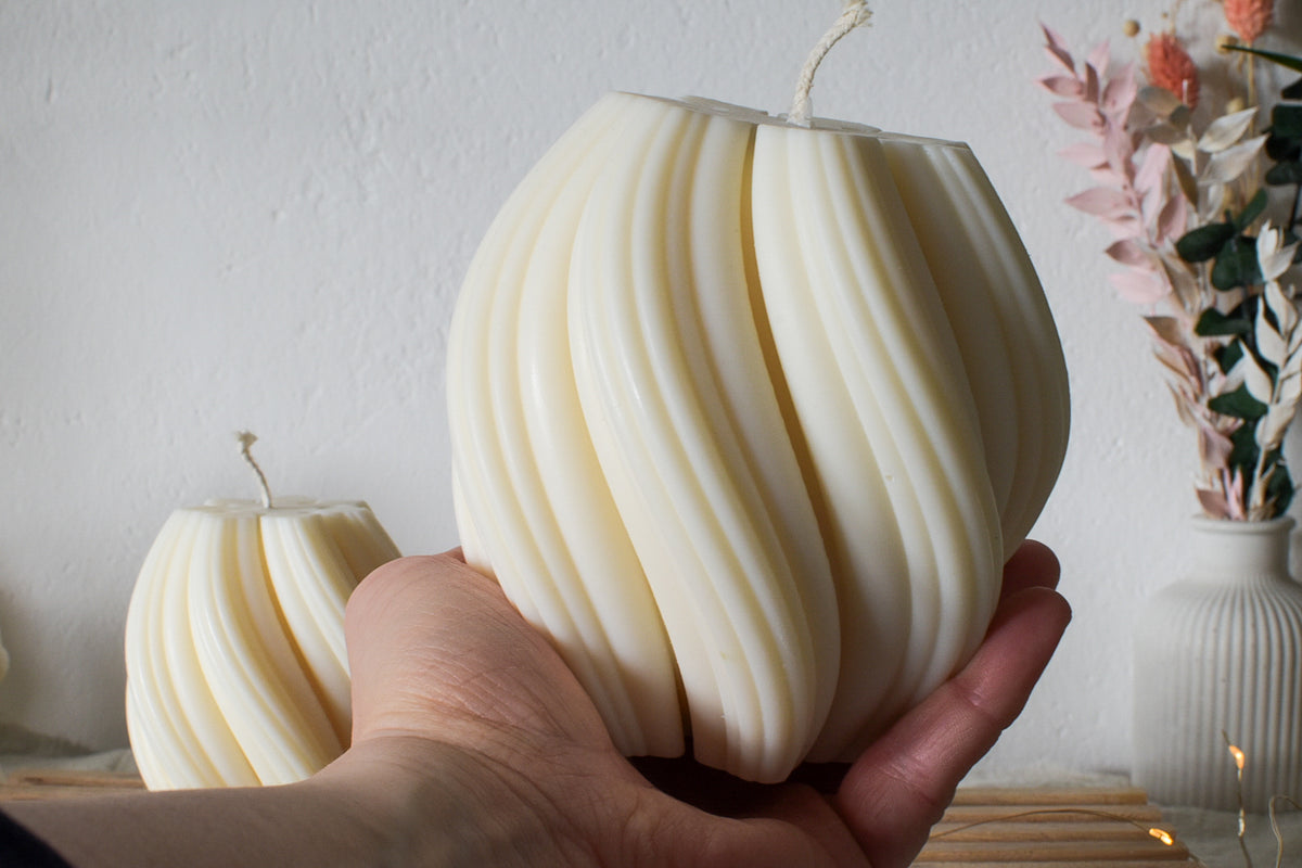 Große Swirl-Kerze in der Hand, daneben eine kleinere