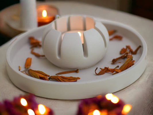 Warmes Licht scheint durch Aussparungen im Beton-Teelichthalter – moderne, stimmungsvolle Deko.