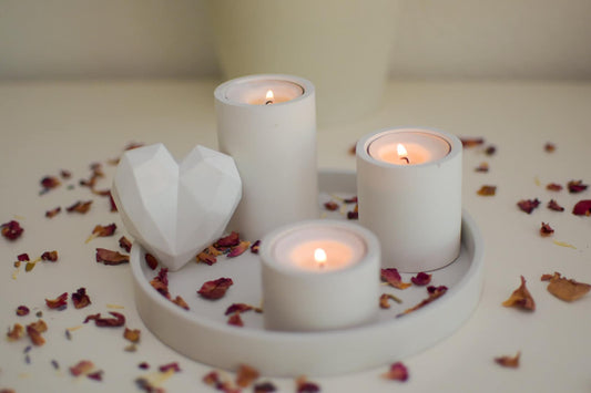 Moderner Teelichthalter aus Feinbeton in Ice-Grau auf gedecktem Tisch