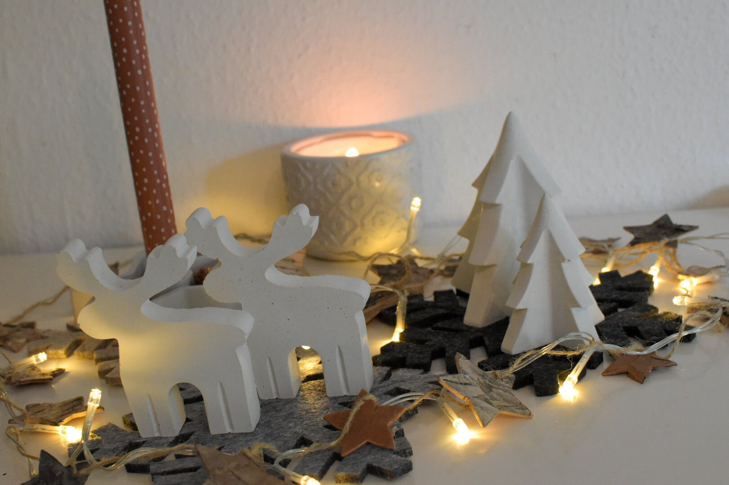 Stimmungsvolle Weihnachtsdeko: Kleiner Beton-Elch auf Betontablett mit Tannenzweigen und Kerzen