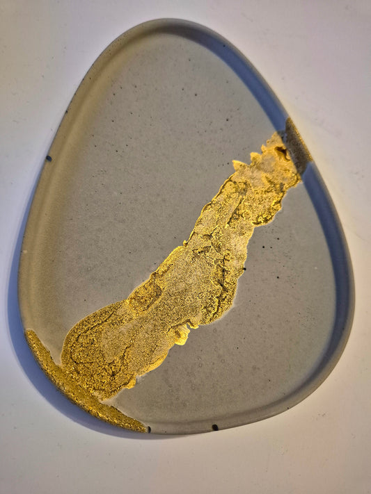 Dreieckiges Betontablett aus Feinbeton mit goldenem Streifen als moderne Betondeko