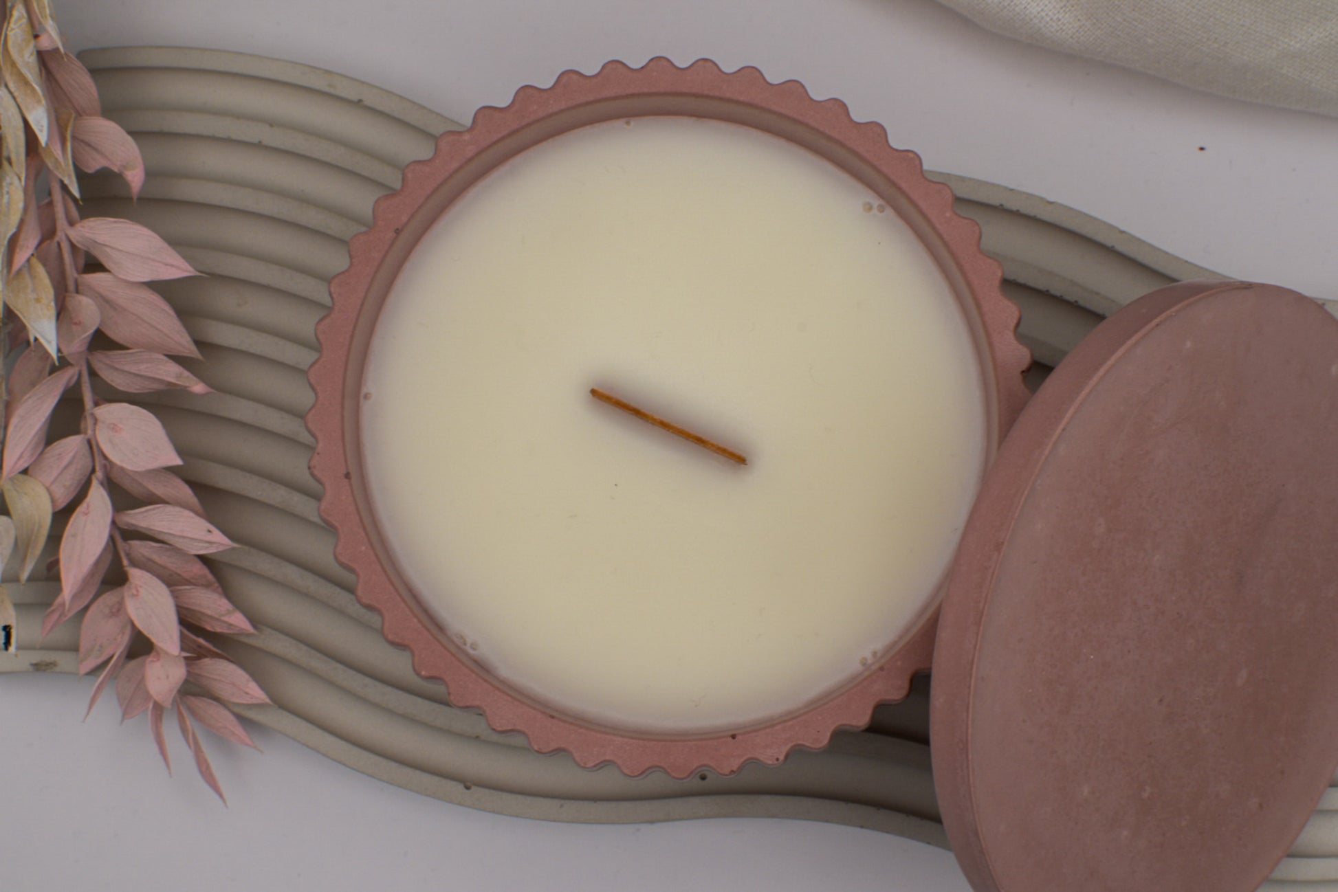 Betondekoration, Ansicht von oben, Betonkerze mit breitem Holzdocht aus Sojawachs, steht auf einem minimalistischen Betontablett, Tablett aus Beton