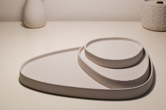 3 handgegossene Betontabletts in Eisgrau mit asymmetrischem Design – ideal als stilvolle Untersetzer oder lebensmittelecht versiegelte Ablage für trockene Lebensmittel.